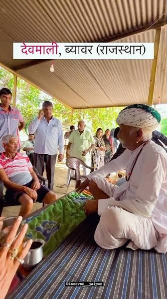 Devotee receiving blessings from a village elder at Devmali shrine